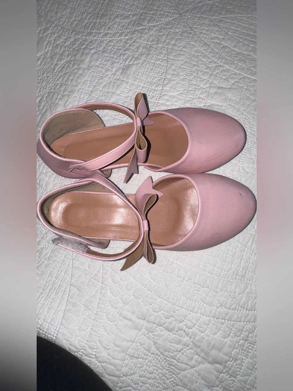 These pastel pink Mary Janes feature a delicate crisscross ankle strap adorned w